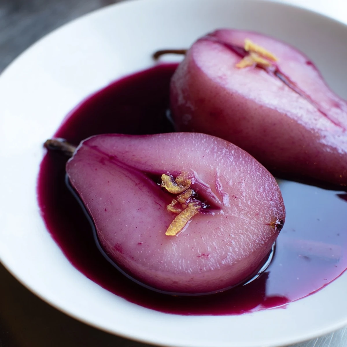 Tender Pears in Grape Juice, simmered to perfection, garnished with fresh mint leaves and a scoop of creamy vanilla ice cream.  