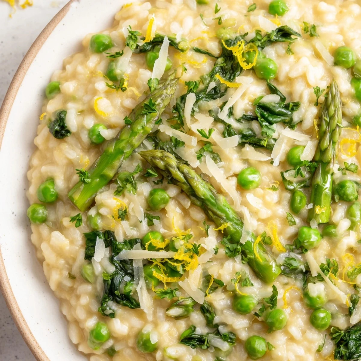 Spring Vegetable Risotto with Lemon Zest shows fresh parsley, a Parmesan garnish, and tender vegetables for a cozy vegetarian main dish.