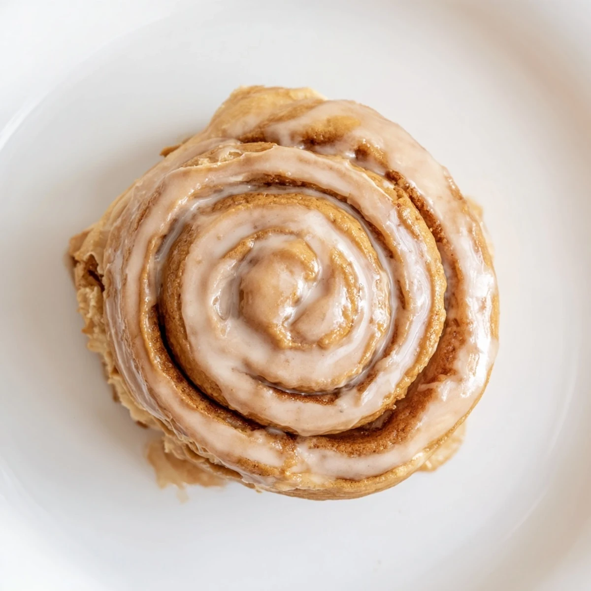 Freshly baked soft and gooey Biscoff cinnamon rolls fresh from the oven, glistening with a sweet glaze.