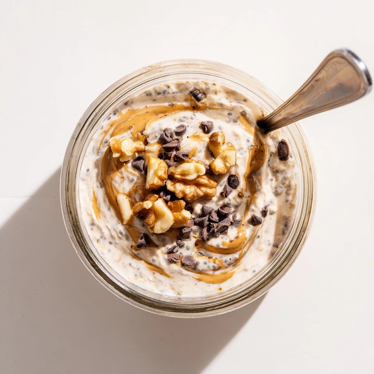 This Cookie Dough Overnight Oats recipe shows a chilled, spoonable breakfast layered with Greek yogurt, almond butter, and chocolate.