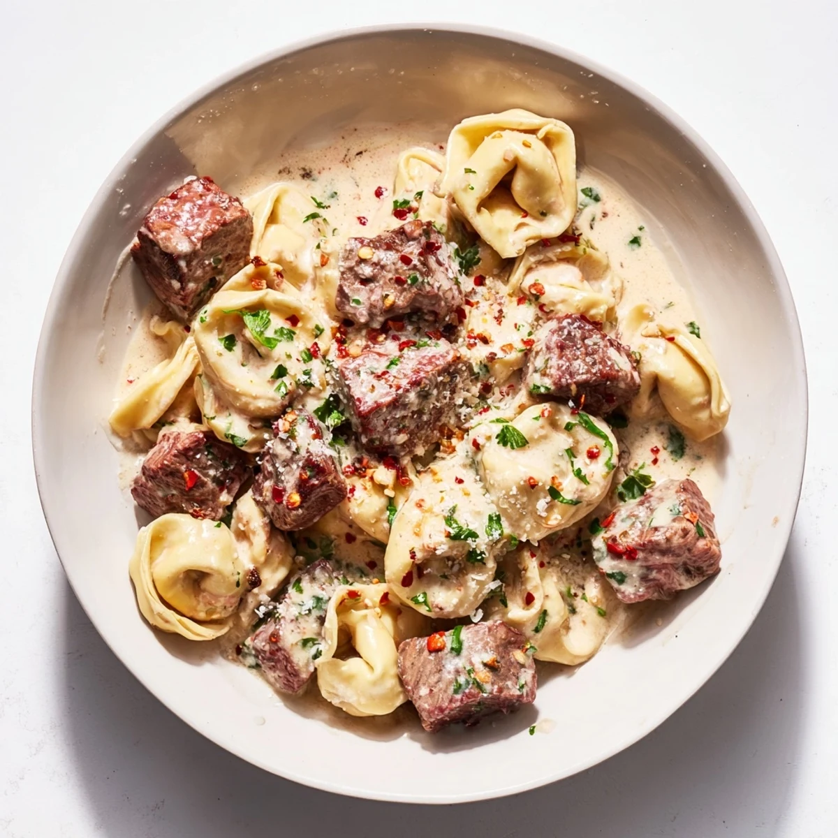 Garlic Steak Tortellini plated with fresh parsley and grated Parmesan, ready for a cozy Italian-American dinner.