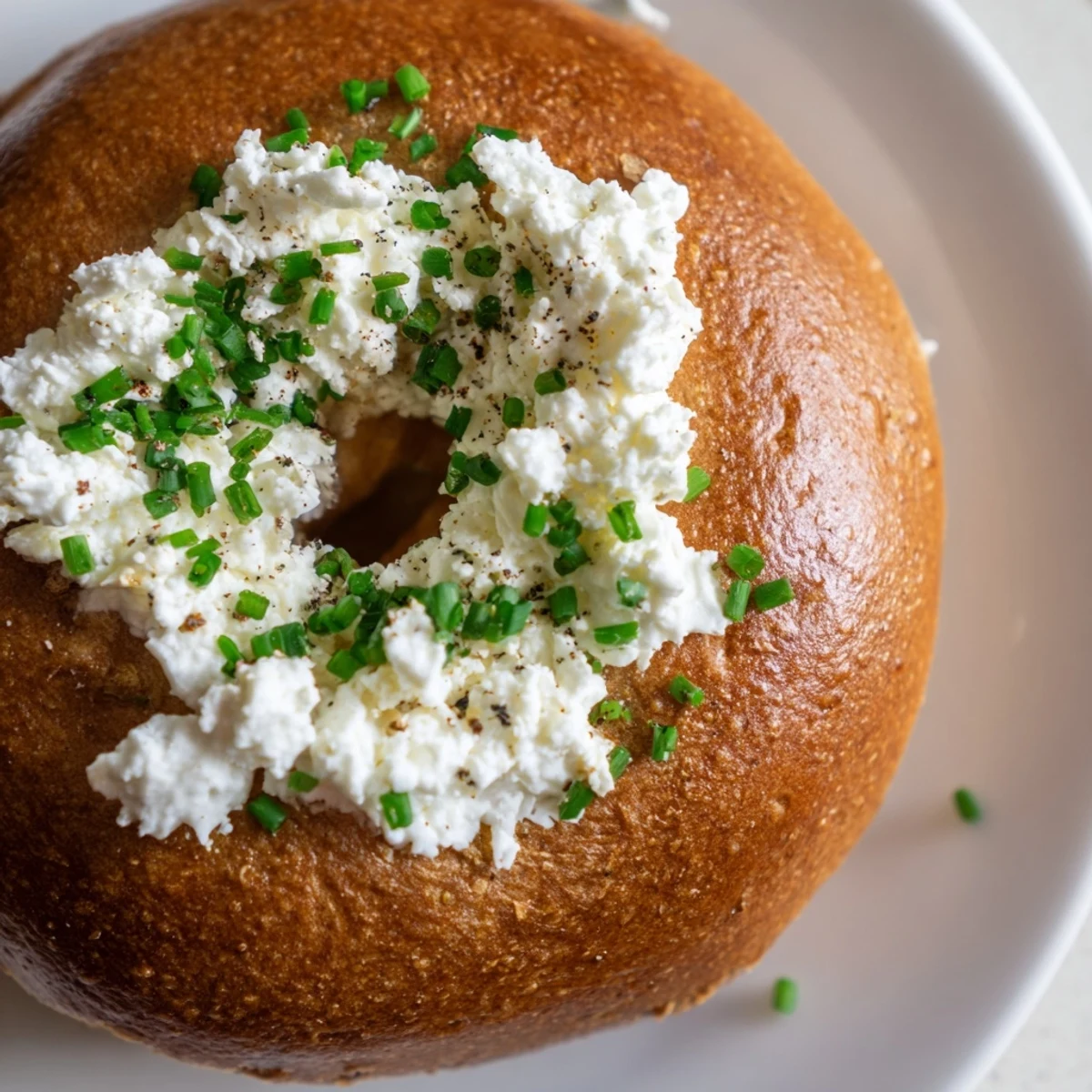Freshly baked golden Protein Bagels with Cottage Cheese topped with creamy cottage cheese and fresh chives.