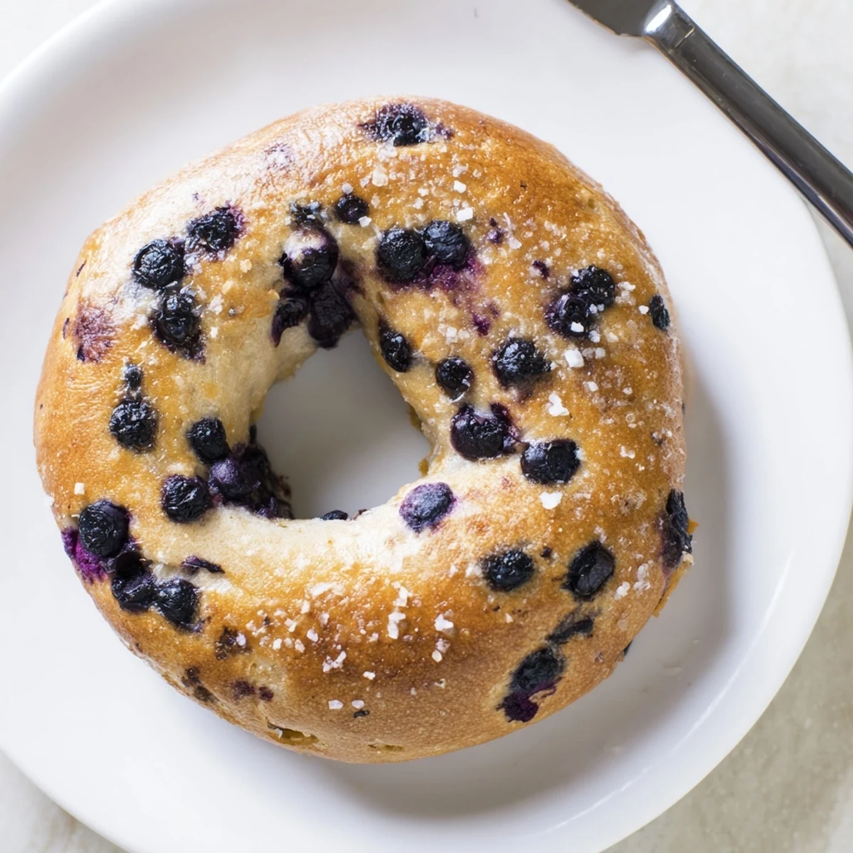 Gluten-Free Blueberry Bagels sliced in half to reveal a chewy interior studded with sweet blueberries, ideal for a healthy snack.