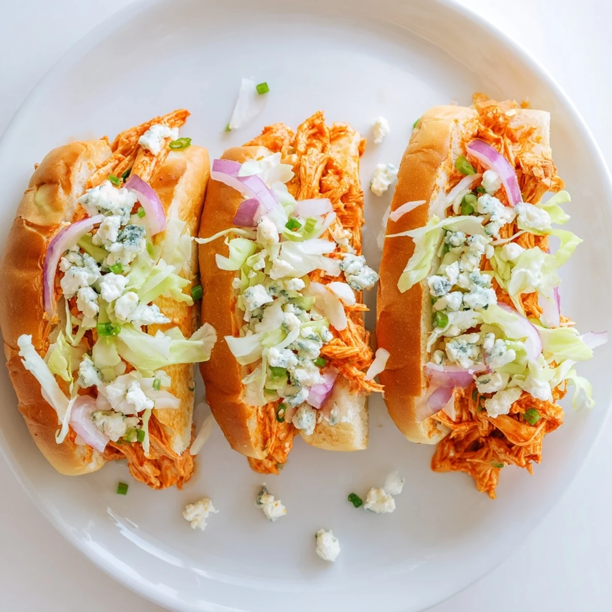 Freshly baked Spicy Buffalo Chicken Sliders with shredded chicken, tangy sauce, and crunchy lettuce on soft buns.  