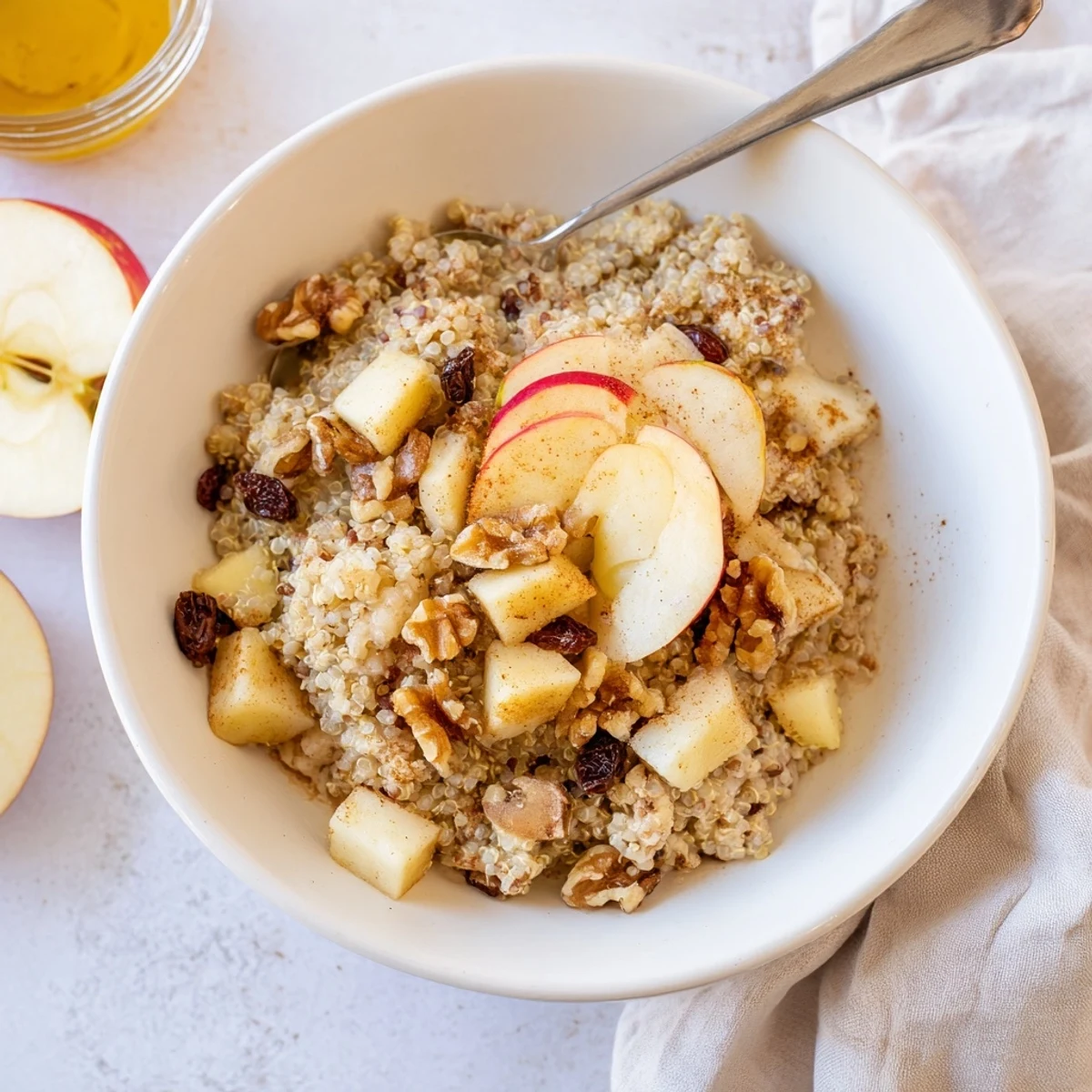 Steaming Healthy Quinoa Apple Breakfast in a rustic bowl with fresh apple slices and cinnamon dust.