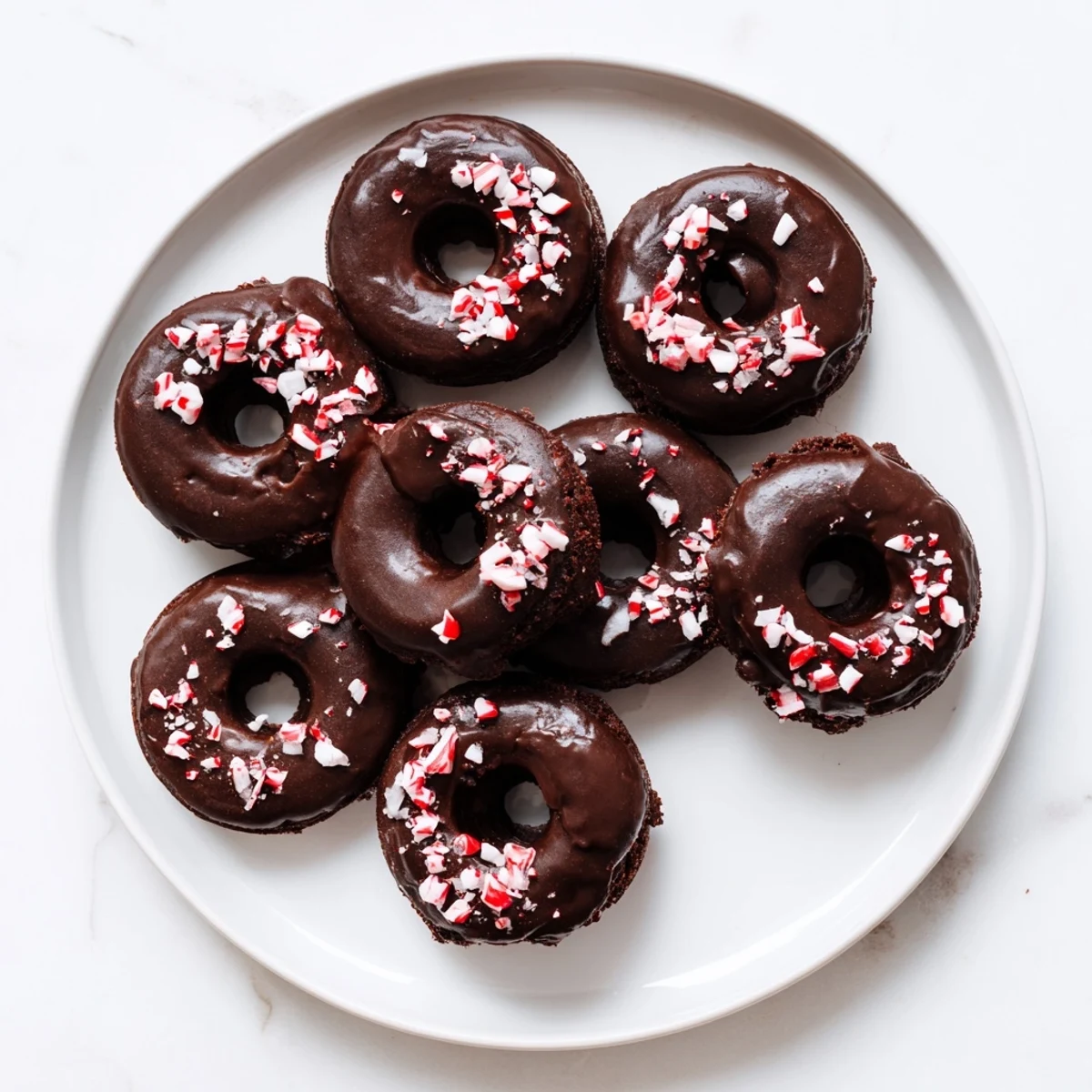 A close-up of a Chocolate Peppermint Mochi Donut showing its soft, chewy texture and a drizzle of rich chocolate glaze.