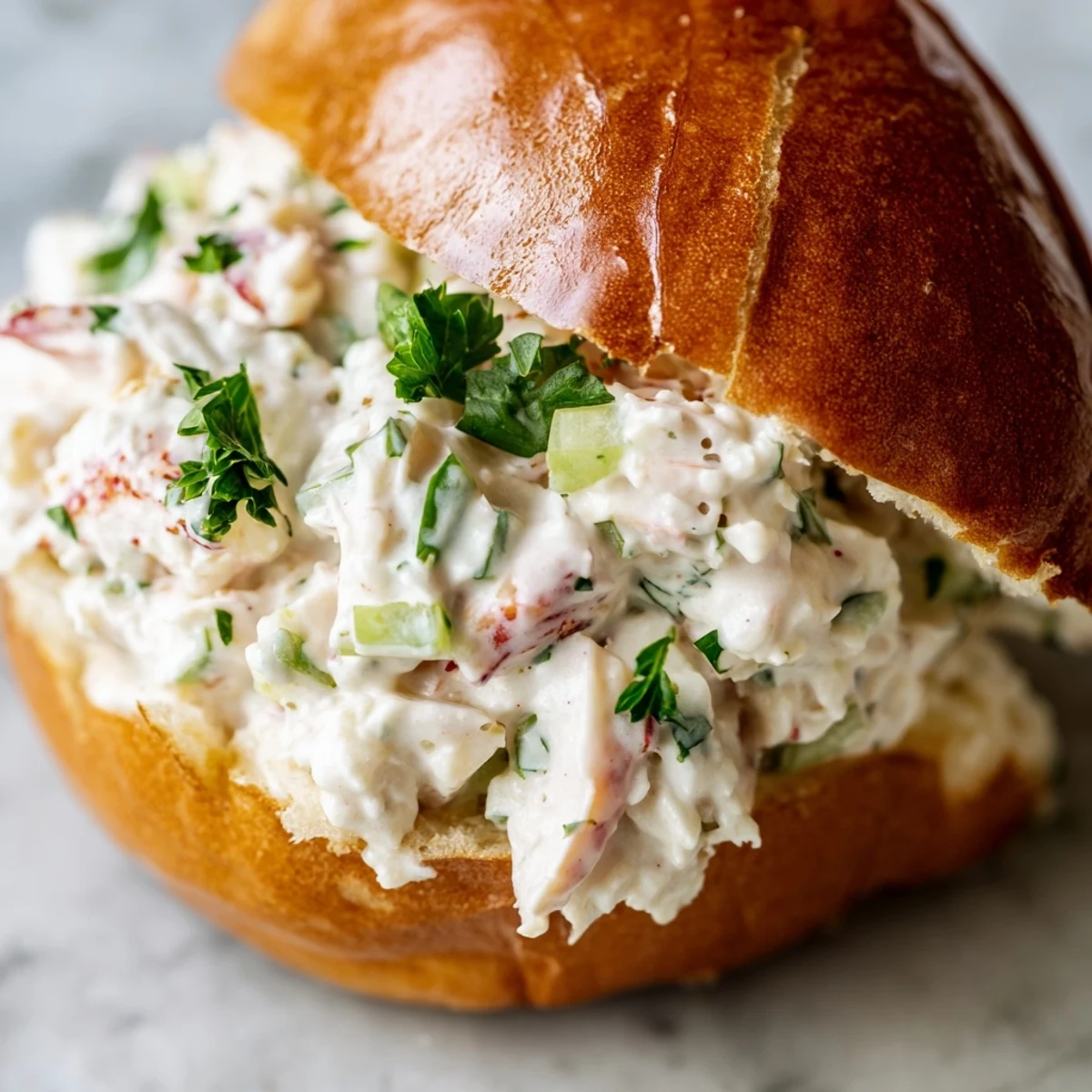 Rich lobster meat in creamy mayonnaise dressing stuffed into warm butter-brushed brioche rolls