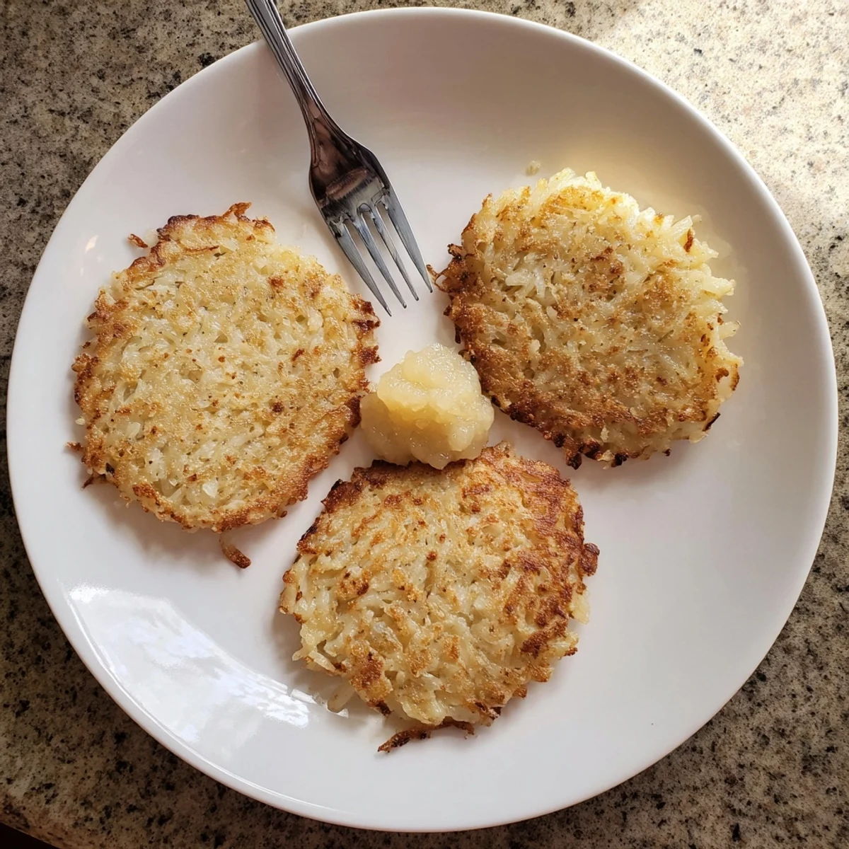 Golden brown German potato pancakes frying in a skillet with crispy edges