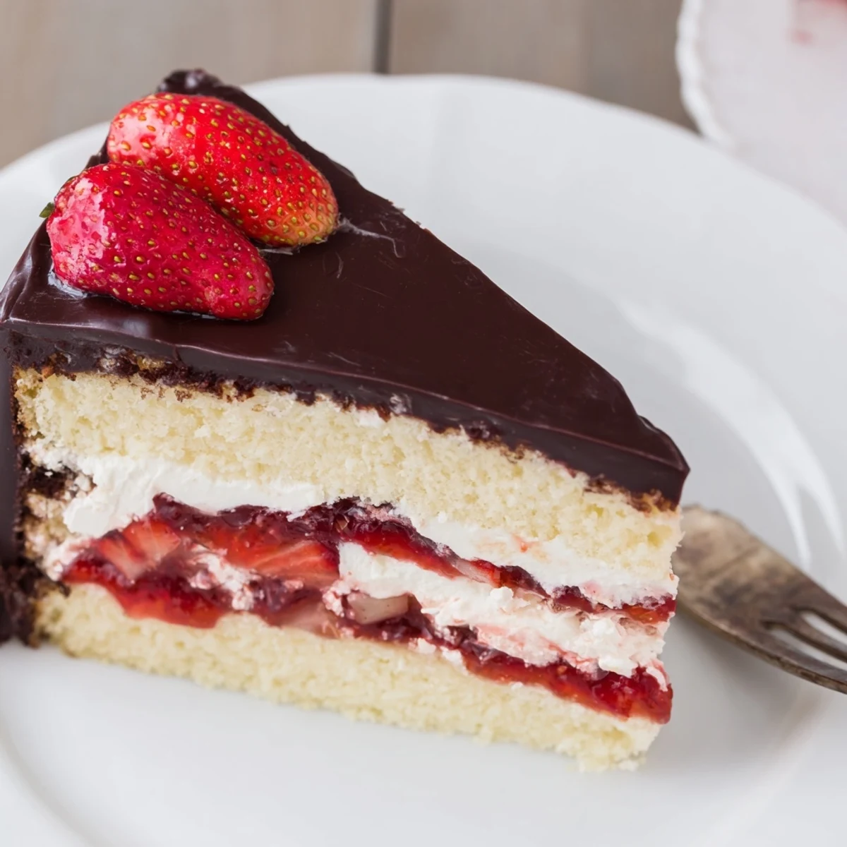 Elegant strawberry chocolate shell cake with glossy dark chocolate coating and fresh berry topping