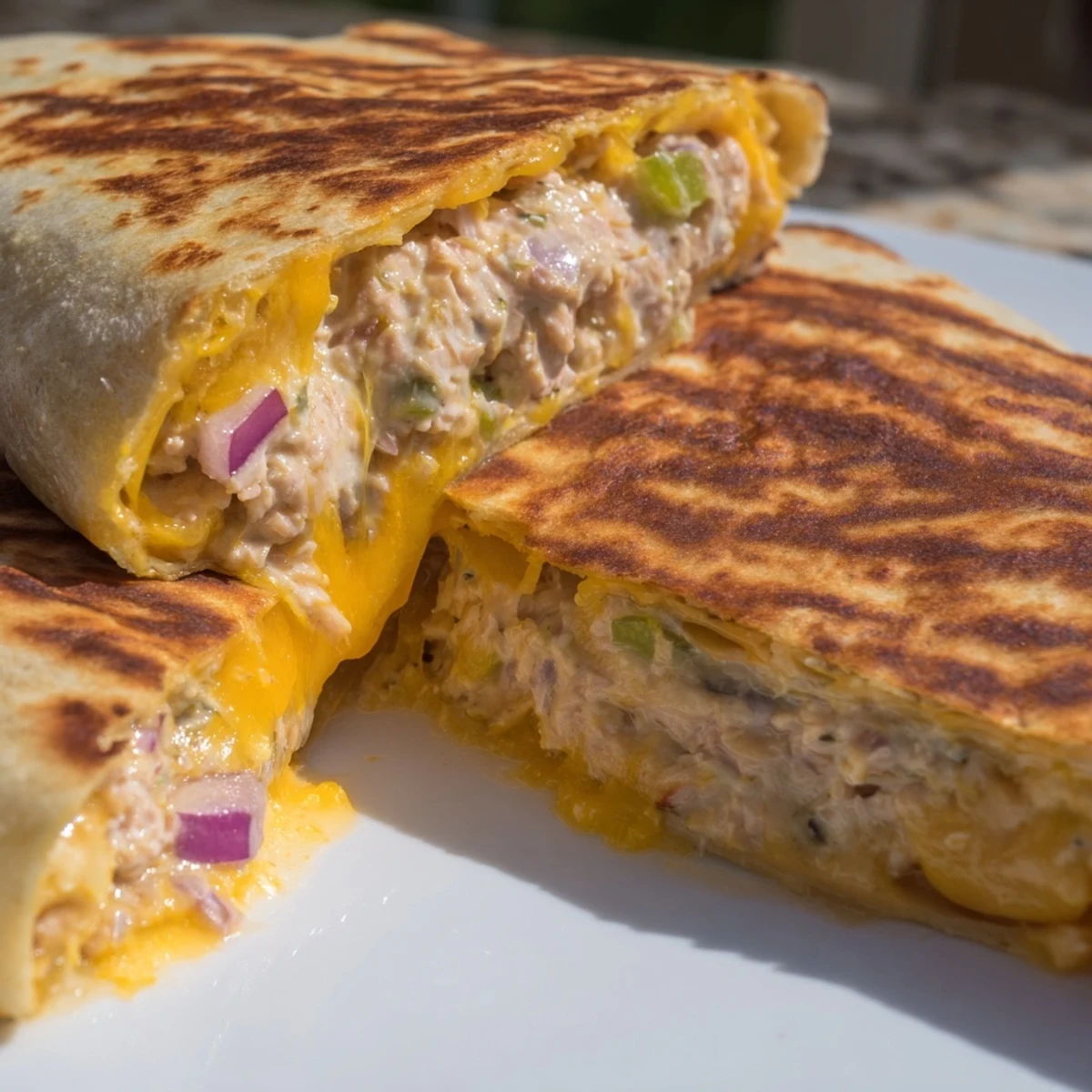Golden grilled tuna melt wrap sliced open revealing melty cheddar and creamy tuna salad filling