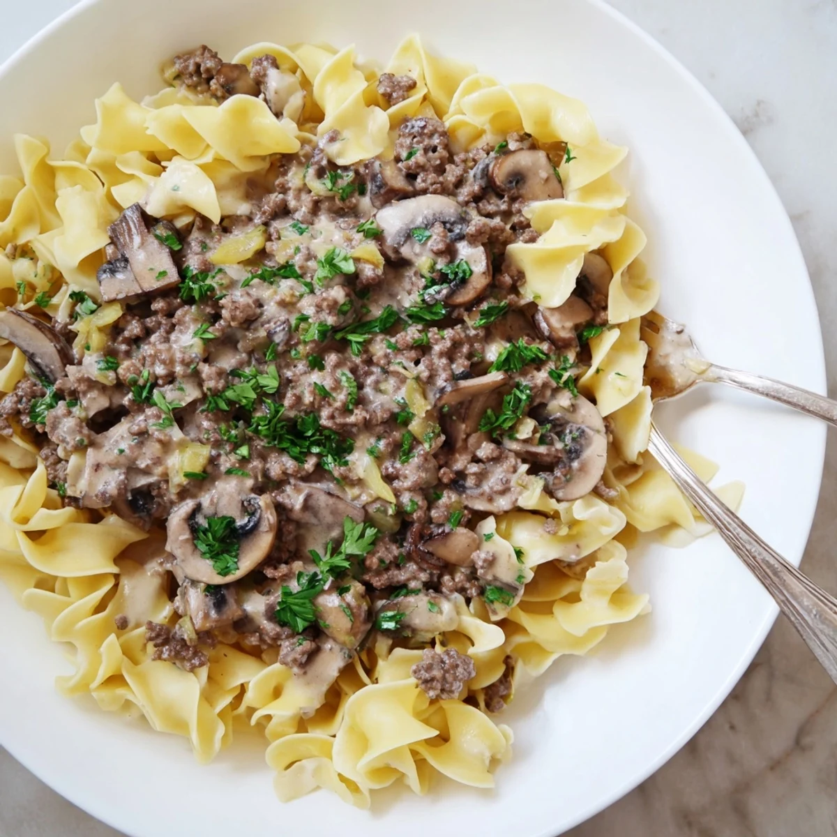 Creamy hamburger stroganoff with tender beef and mushrooms served over egg noodles