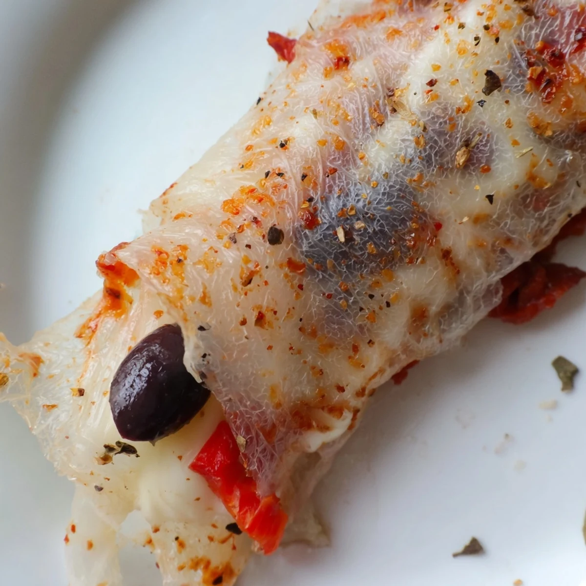 Close-up of rice paper pizza rolls showcasing oozing cheese and diced vegetable fillings