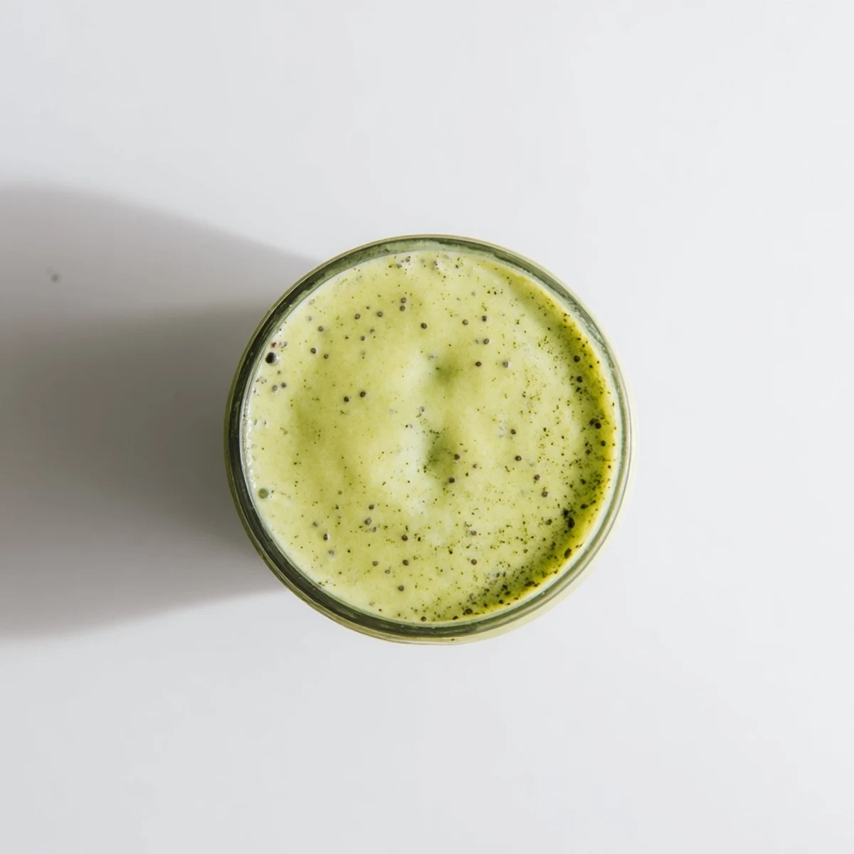 Vibrant green Energizing Banana Matcha Smoothie blended with ripe bananas and almond milk in a clear glass