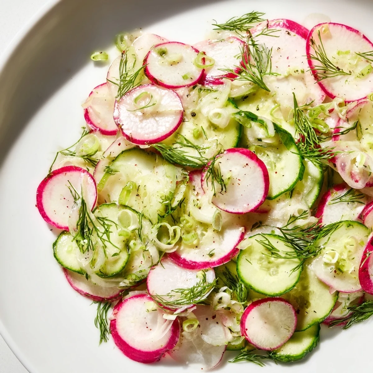 Colorful radish and cucumber salad featuring thin vegetable ribbons in olive oil dressing