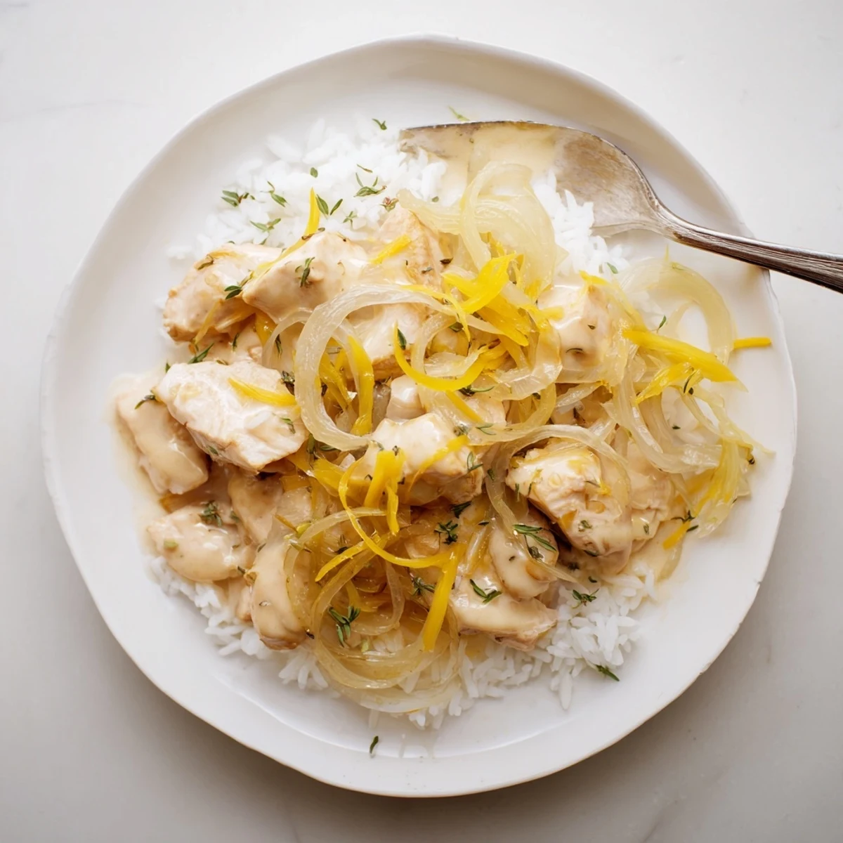 Golden brown chicken breasts resting atop creamy rice with caramelized onions and melted Gruyère cheese