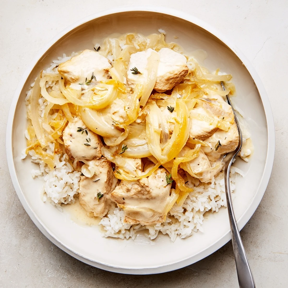 Tender chicken pieces nestled in rich French onion rice sauce with shredded cheese and golden onions