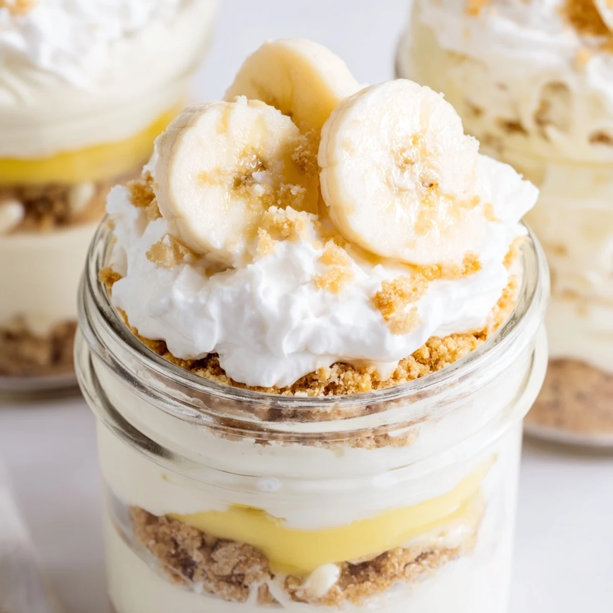 Creamy banana pudding cheesecake cups layered with fresh banana slices and vanilla wafer crumbs