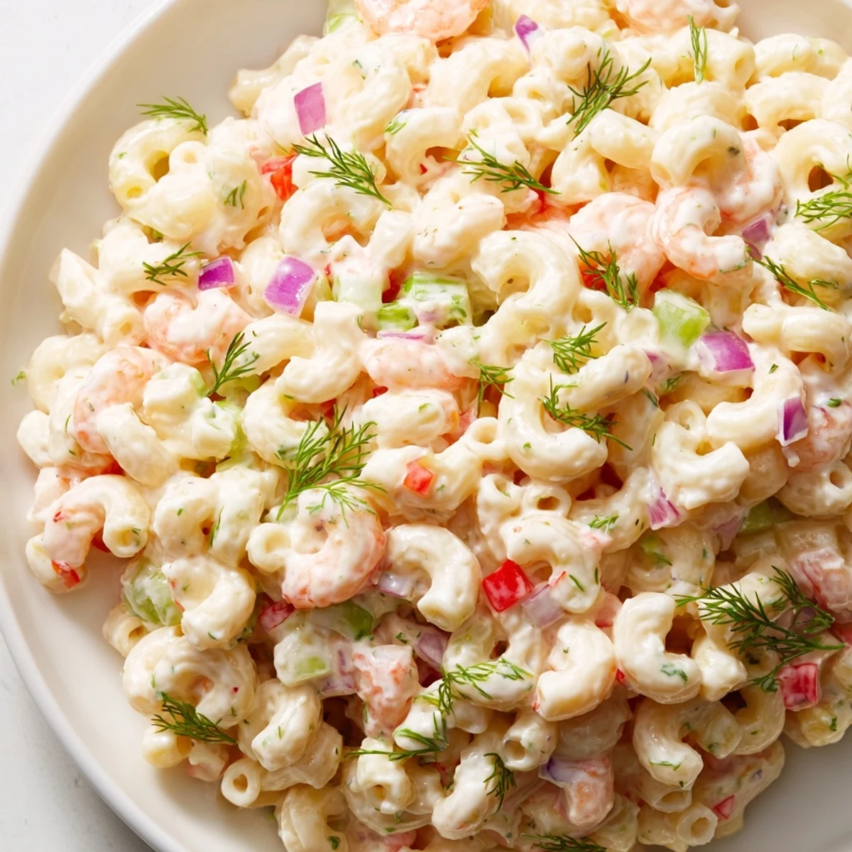 Chilled shrimp macaroni salad topped with tender pink shrimp and crisp vegetables