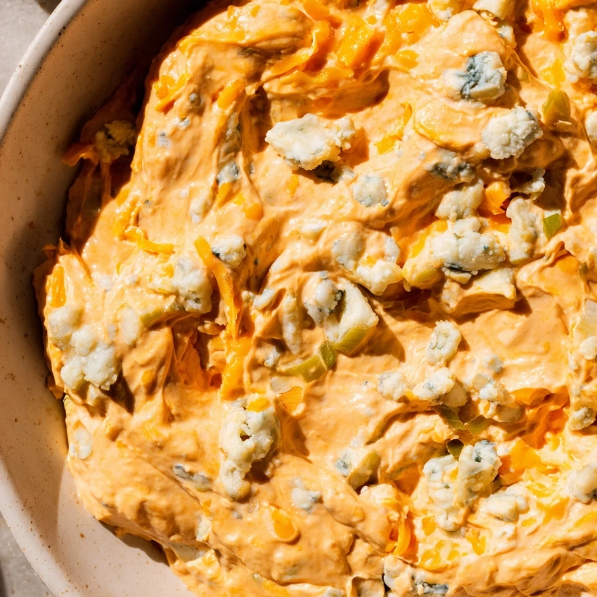 Tangy buffalo pickle dip topped with cheddar cheese and fresh chives ready for game day snacking