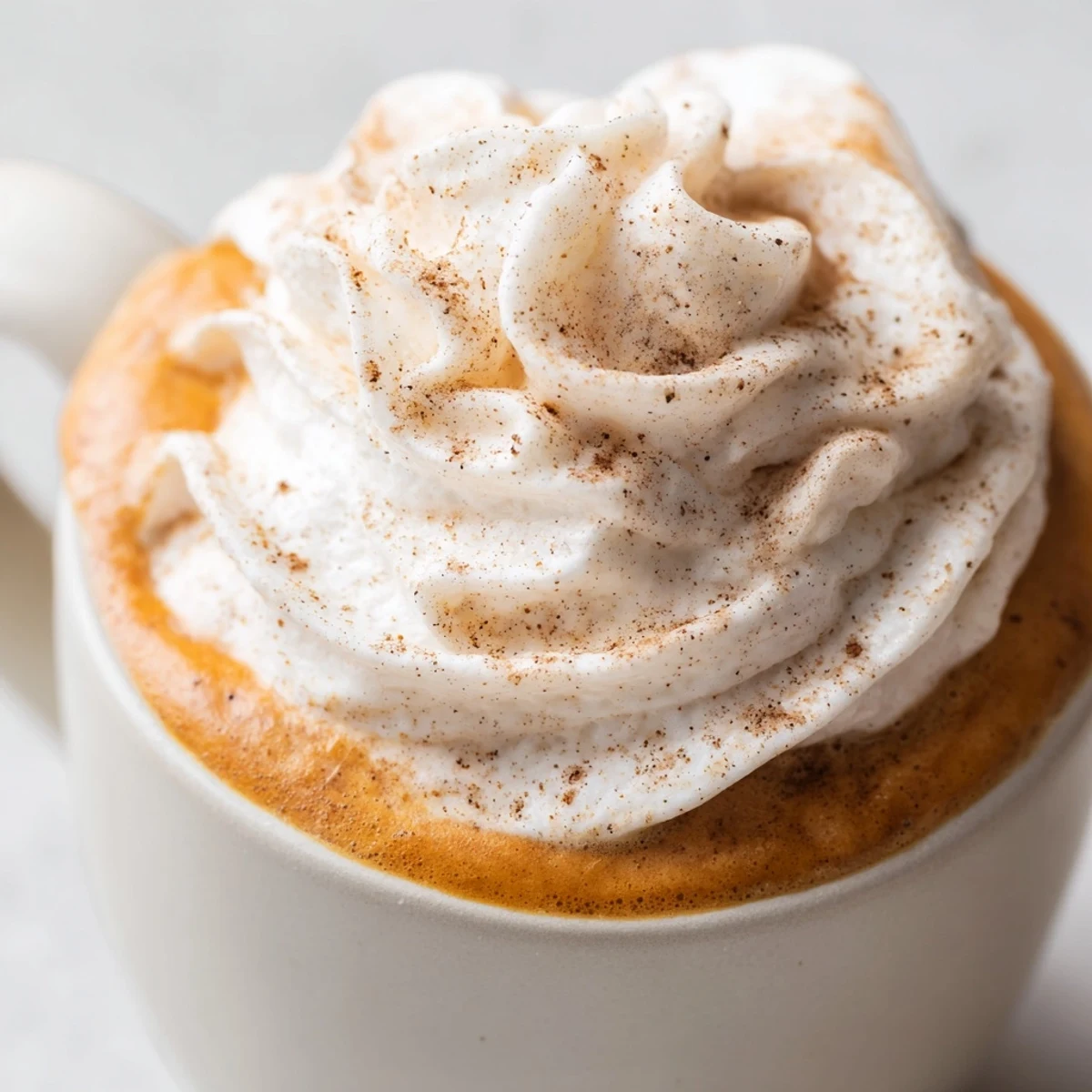 Creamy homemade pumpkin spice latte in a cozy mug on an autumn morning