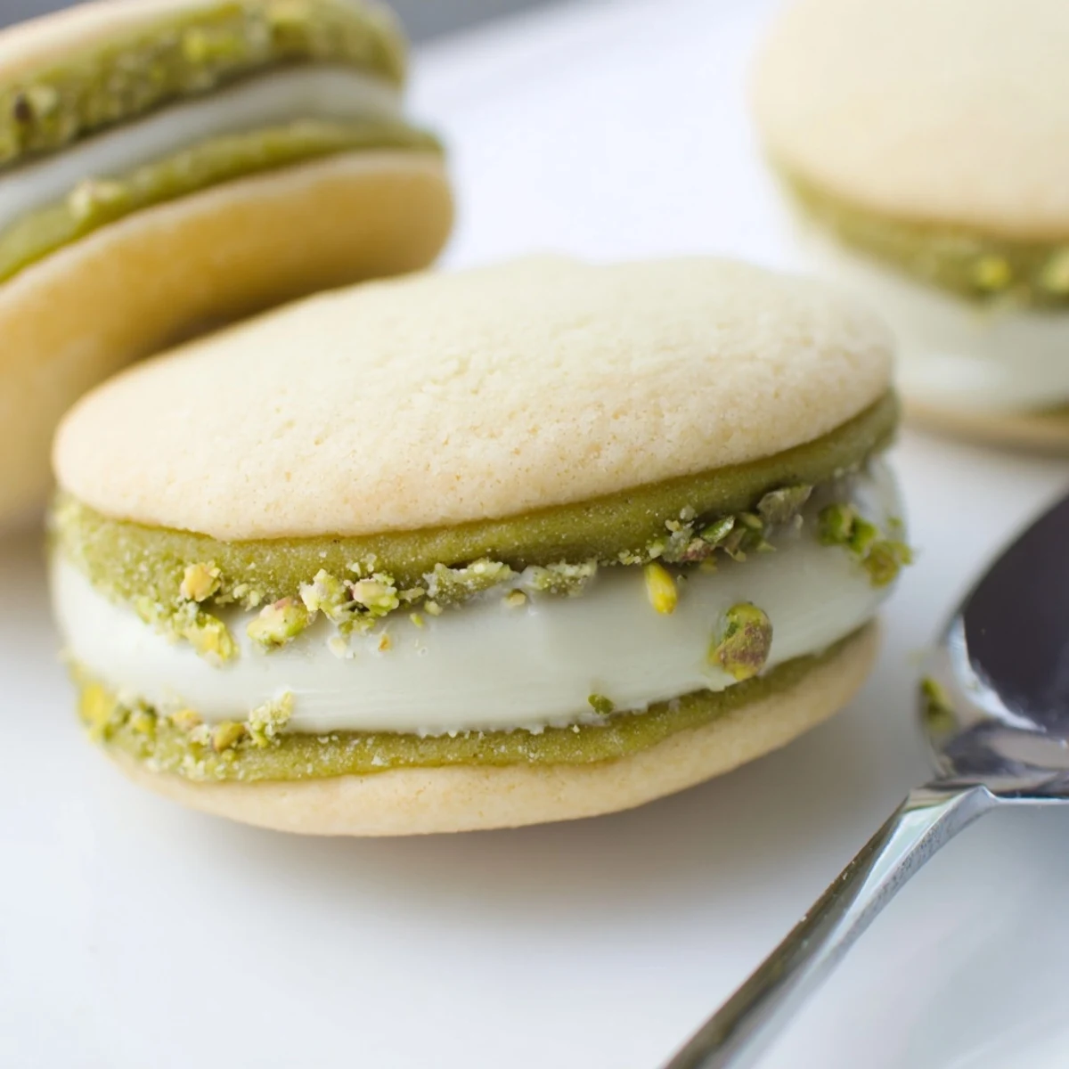 Pistachio Cream Cookies recipe: buttery golden sandwiches with pale green cream, chopped pistachios