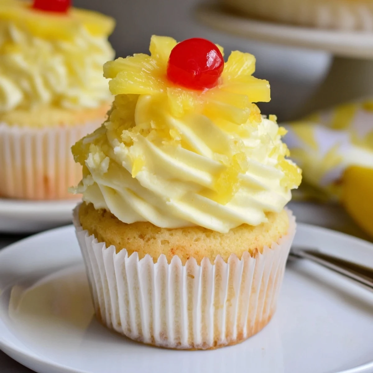 Bite-ready Dole Whip Cupcakes Recipe topped with toasted pineapple and maraschino cherry