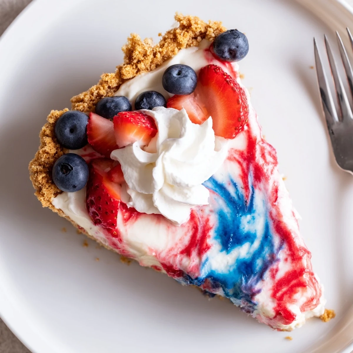 Slice of Patriotic Red White And Blue Swirl Pie on plate, creamy texture