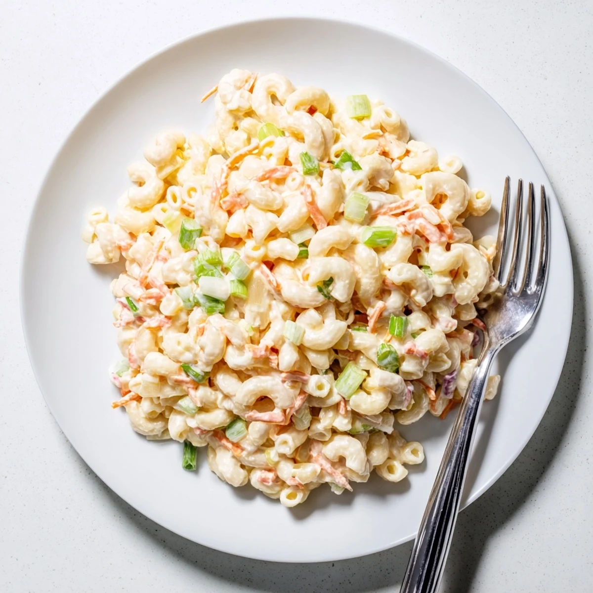 Hawaiian style mac salad featuring soft pasta tossed in tangy mayonnaise dressing with finely chopped celery and carrots
