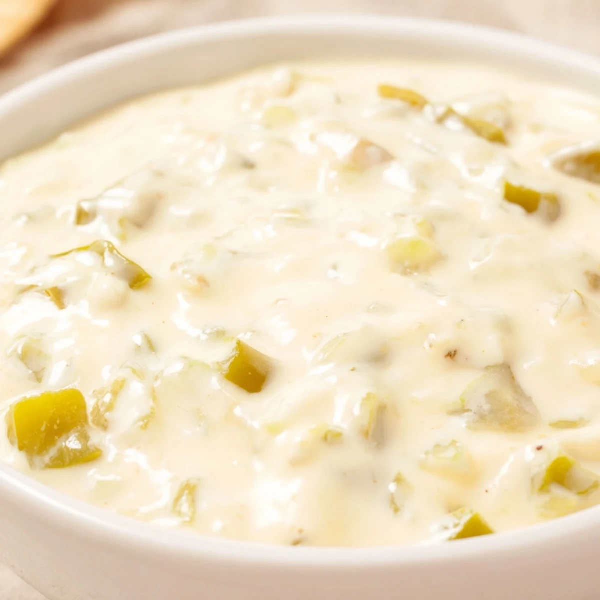 Rich and smooth white queso dip featuring jalapeños and spices, perfect for your next party or game night gathering