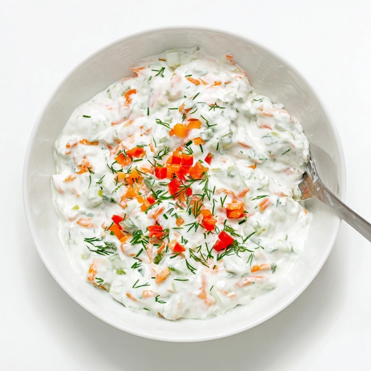 Light and creamy fresh vegetable spring garden dip topped with diced red bell pepper and fresh green herbs