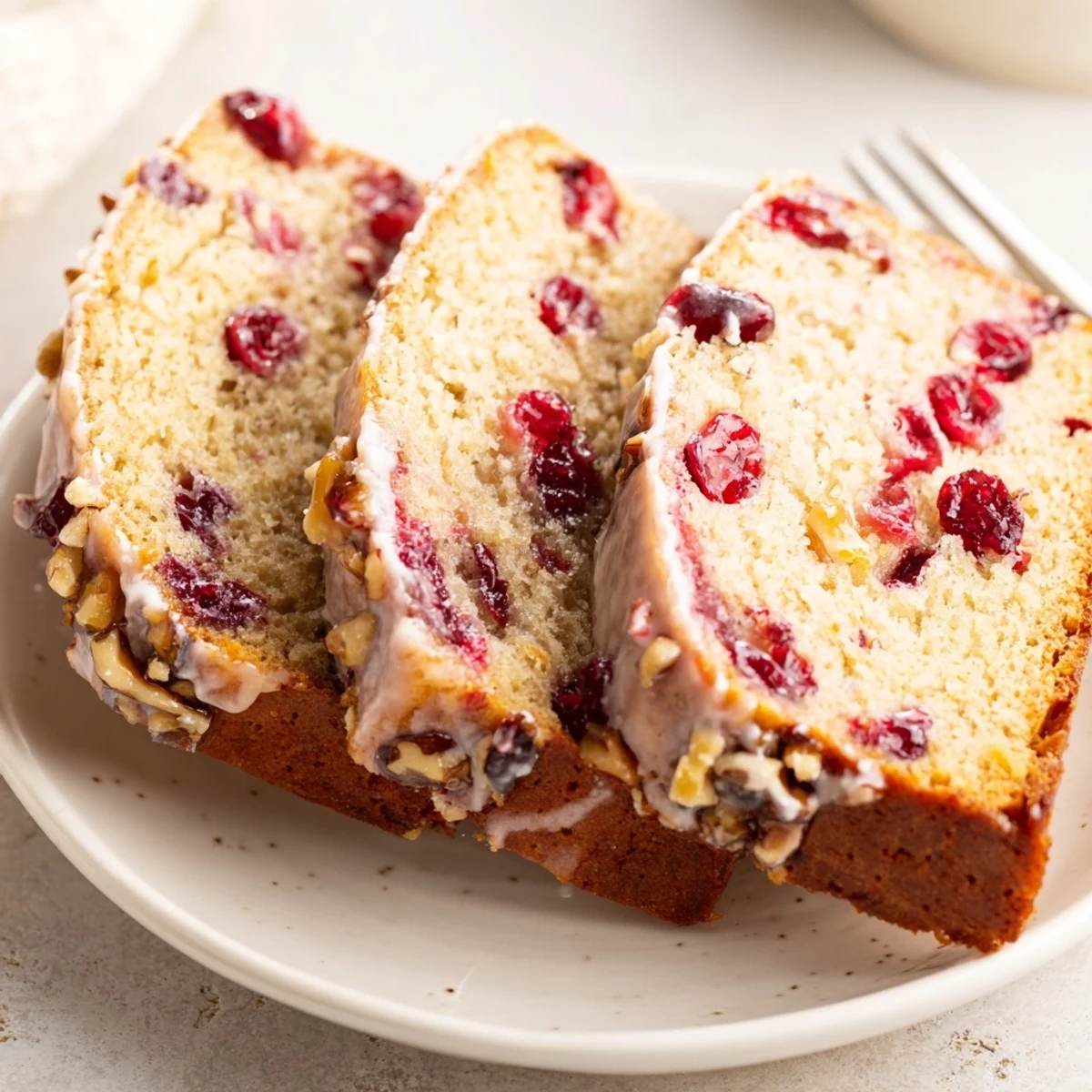 Cranberry Orange Bread topped with citrus glaze, fragrant aroma, perfect with tea