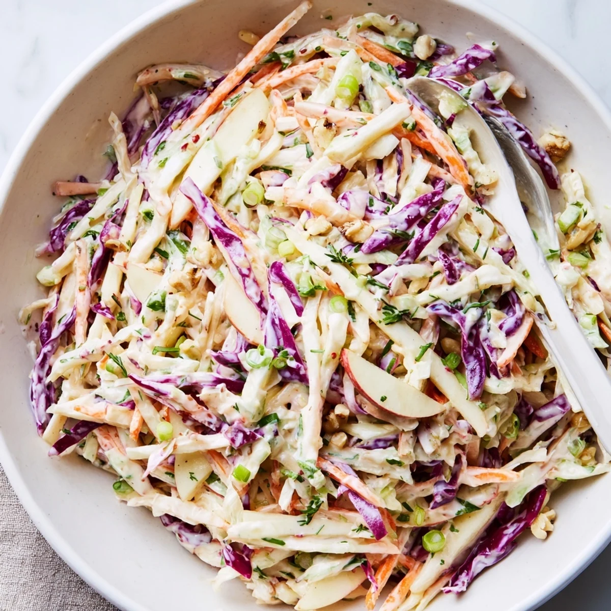 Shredded green and red cabbage in Apple Coleslaw, crisp and served chilled