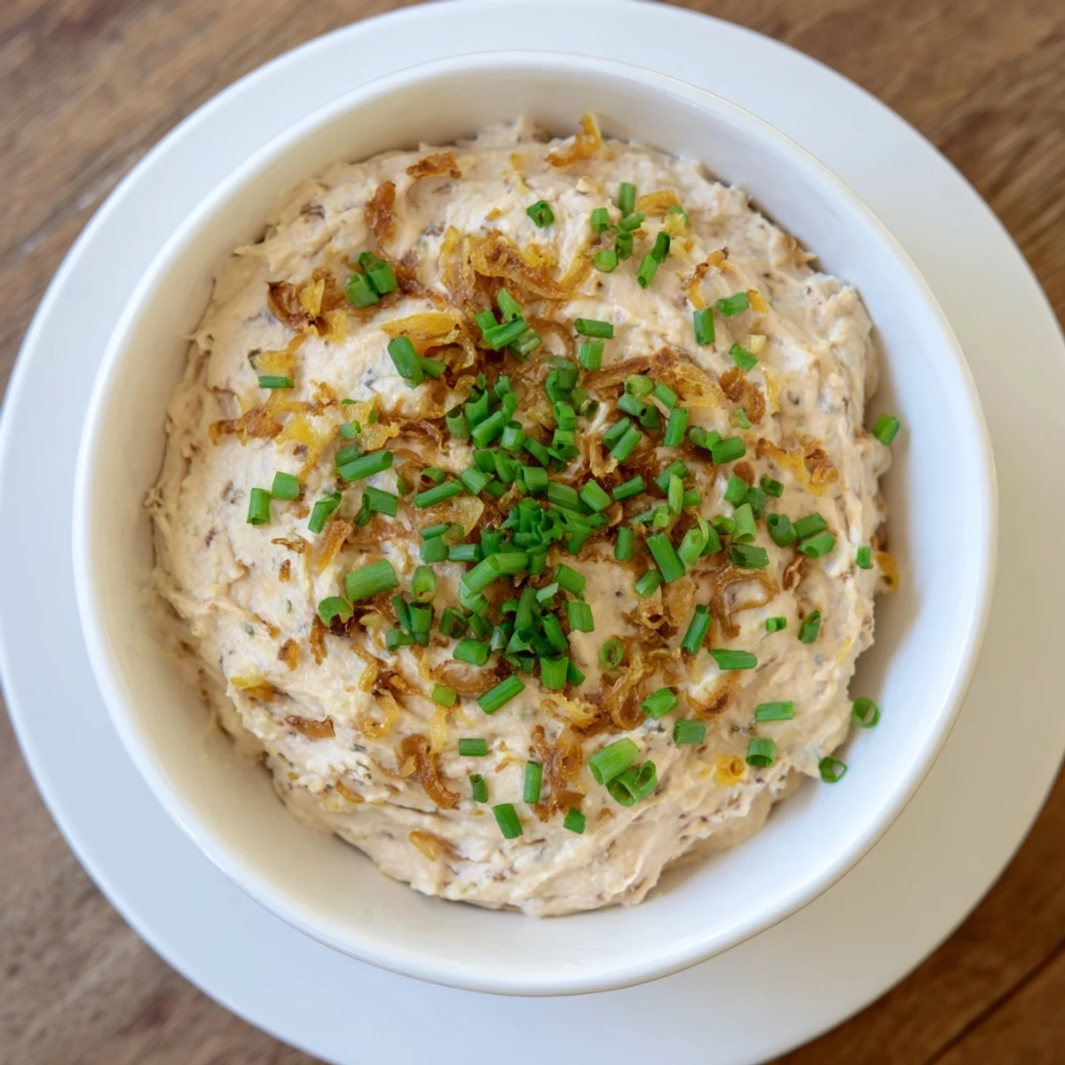 Smooth white French onion dip flecked with sweet savory onions and chopped chives perfect for vegetable crudités