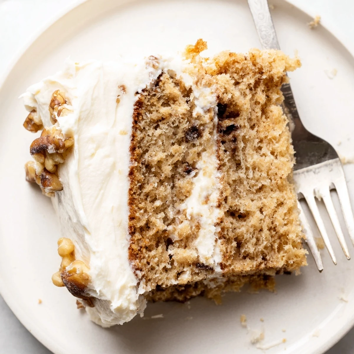 Golden slice of homemade banana cake served on a rustic white plate