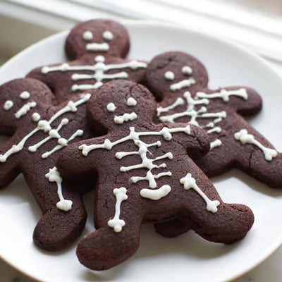Dark cocoa chocolate cinnamon skeleton cookies decorated with intricate royal icing skeleton designs
